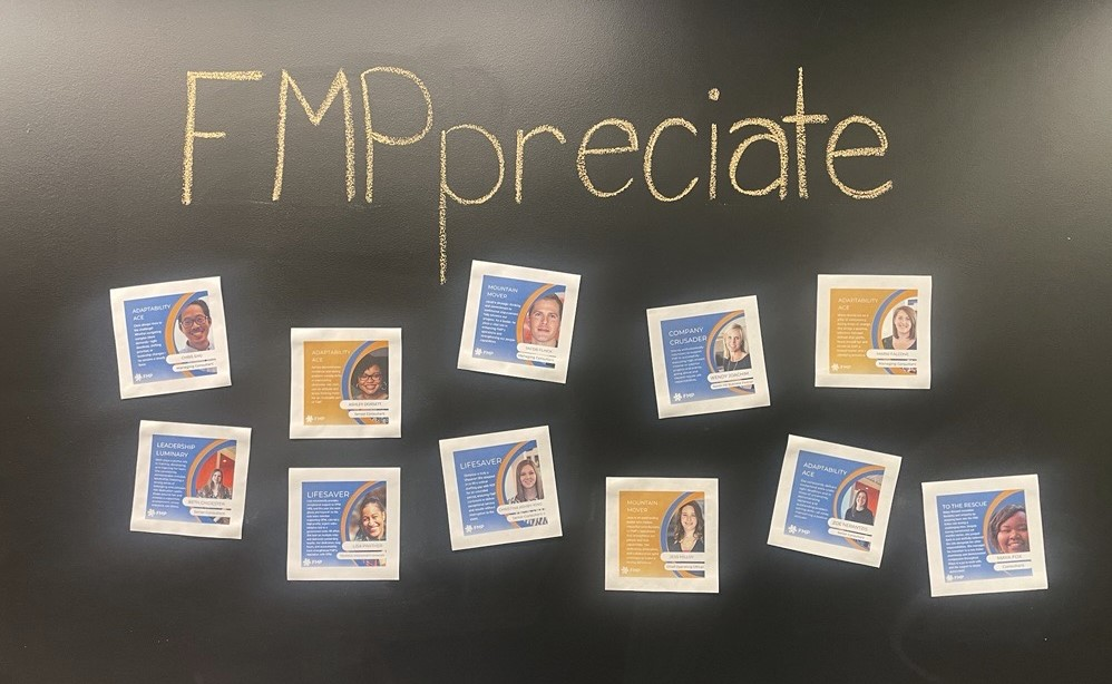 A blackboard with the word "FMPpreciate" written across the top. Images of individual awards are pasted across the blackboard.
