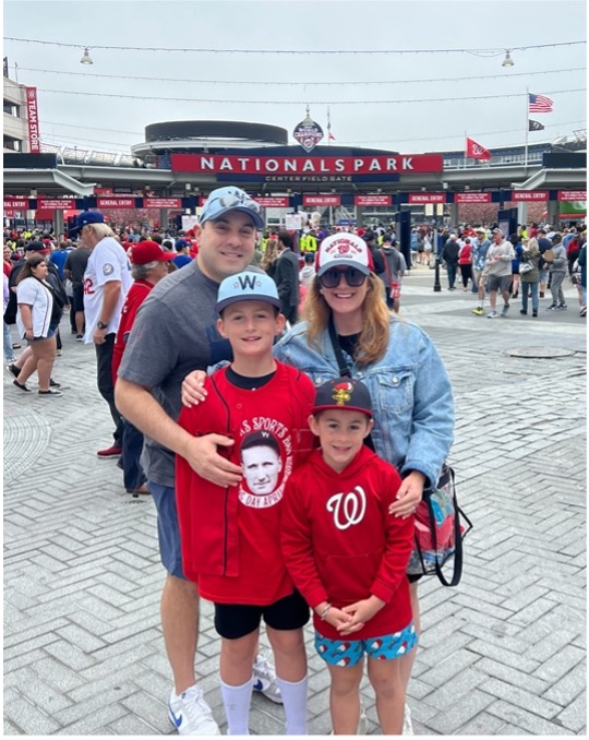 A family dressed in Washington Nationals gear, standing in the entry to Nat's Park in Washington, DC.